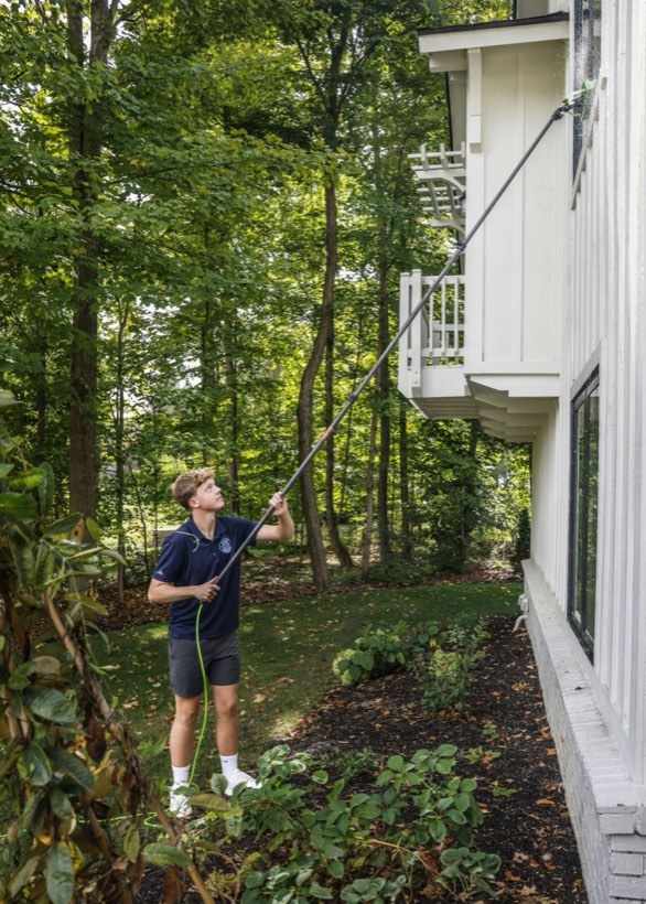 Willis Windows cleaning an upper-story window from the ground with a water-fed pole